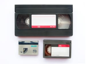 A VHS tape, miniDV tape and a VHS-c tape.