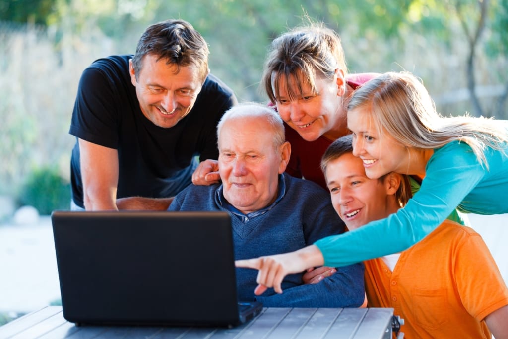 Showing grandfather a fun slideshow at a family reunion