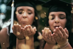 two girl graduates celebrating with graduation slideshow
