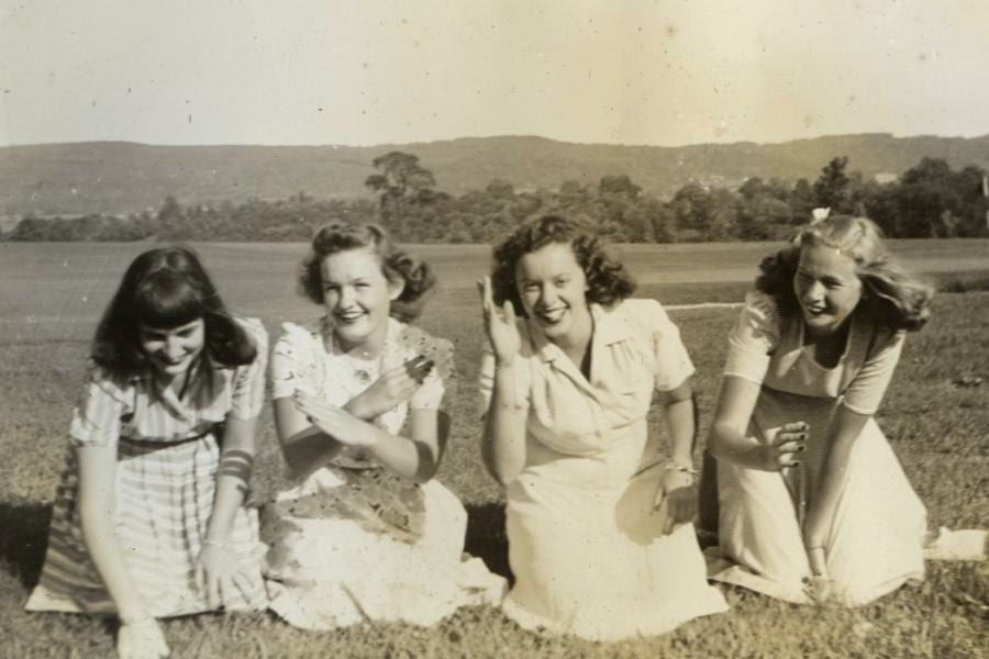 Jean Doern and three friends kneeling on grass at a country club
