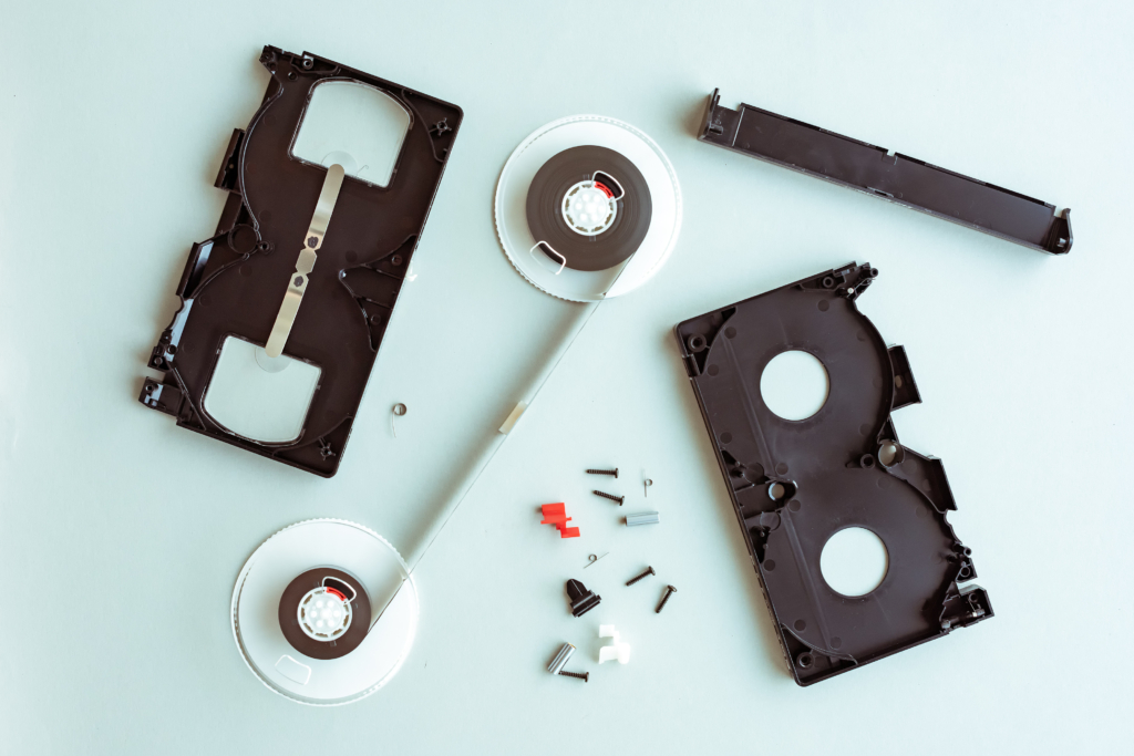 Flat lay vhs video cassette parts on pastel blue background, top view of retro technology and media concept