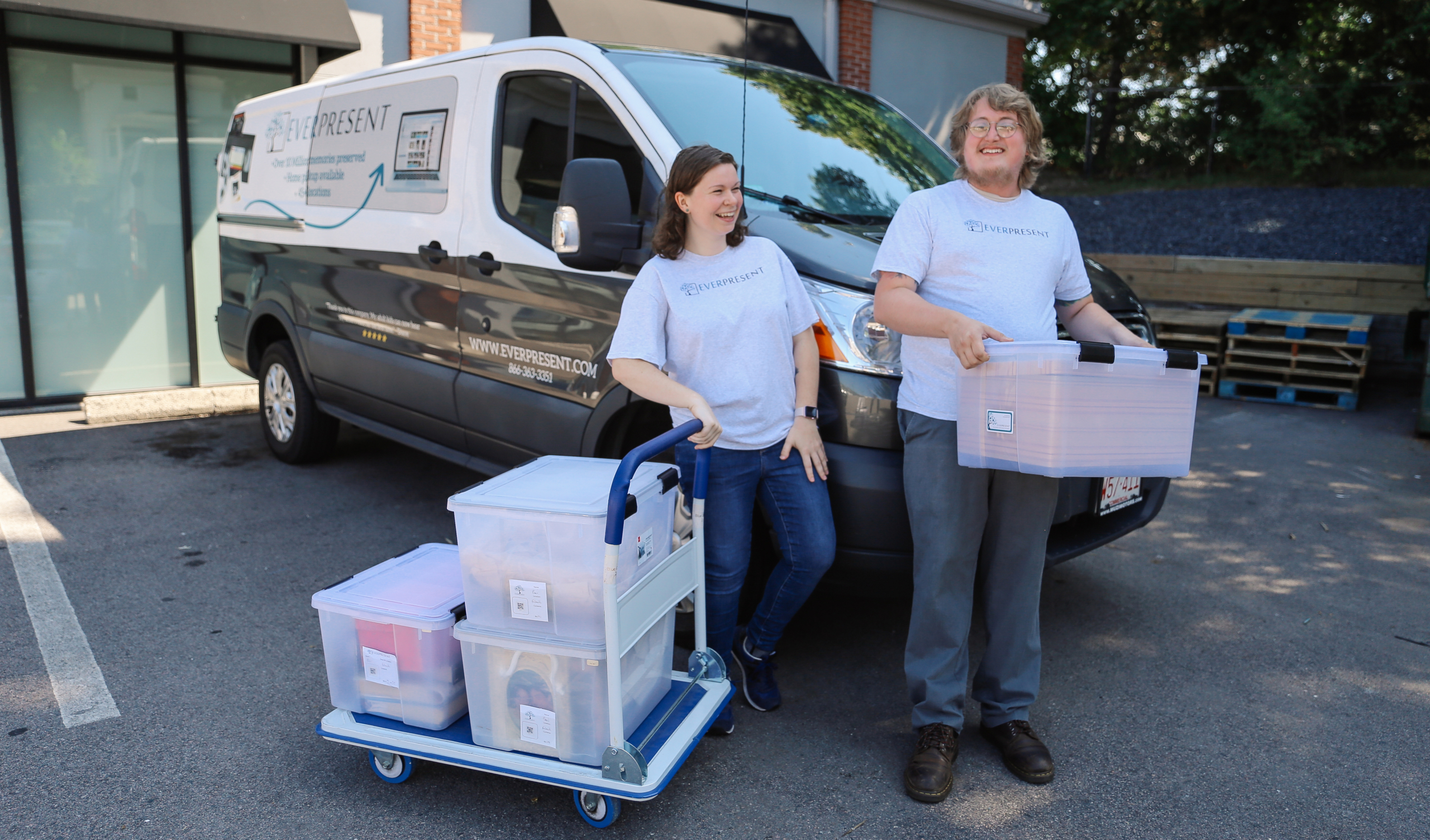 EverPresent staff picking up client projects in front of EverPresent's van.