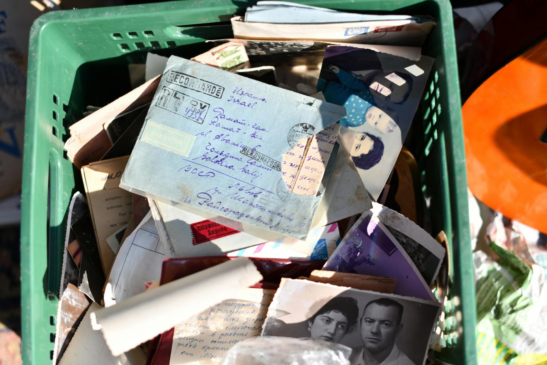 A collection of vintage letters and photographs in an old basket, evoking memories.
