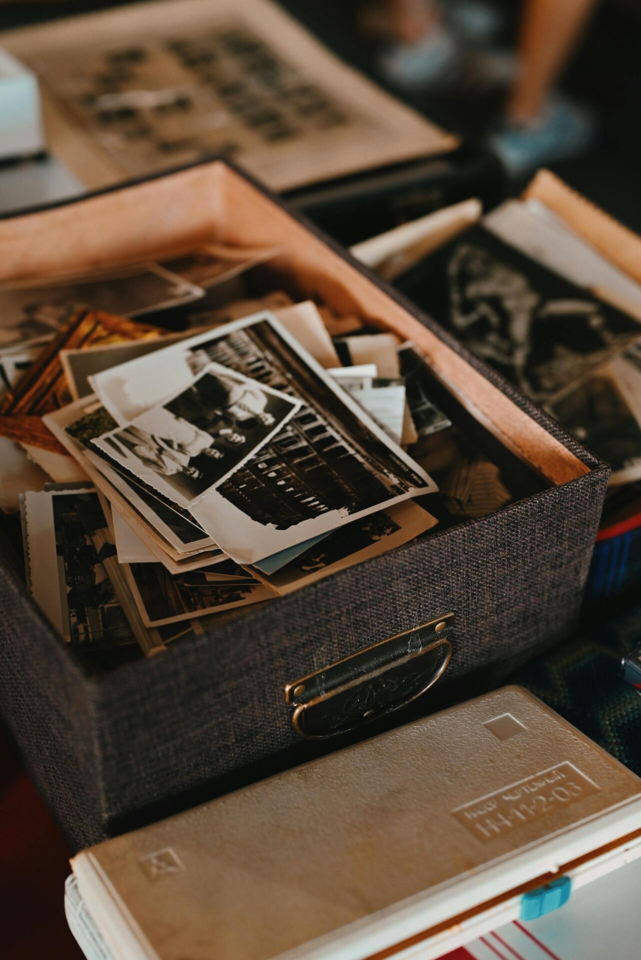 A collection of vintage photographs in a textured box, capturing old memories.