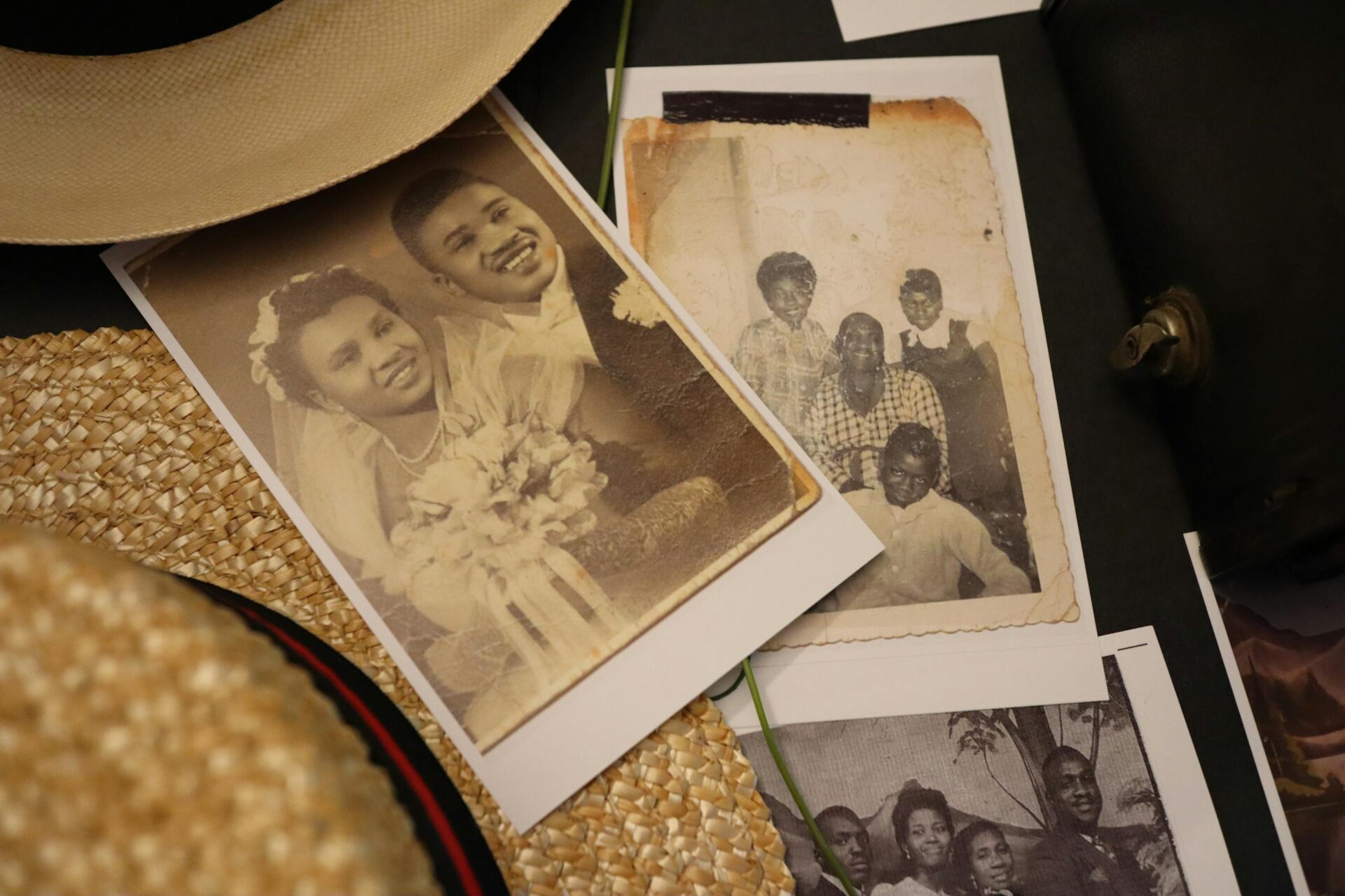 A collection of nostalgic black and white family and wedding photos with a straw hat.
