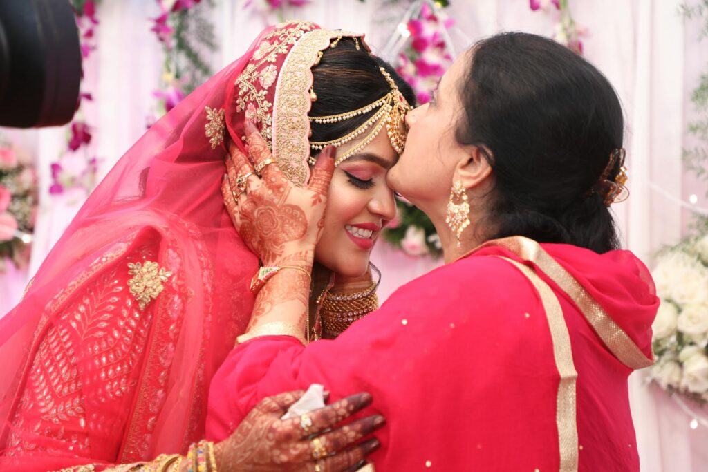 Mother kisses bride in a traditional Indian wedding in Bengaluru, showcasing cultural elegance and familial love.
