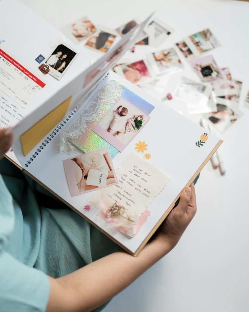 Woman holding a scrapbook filled with nostalgic photographs and art.