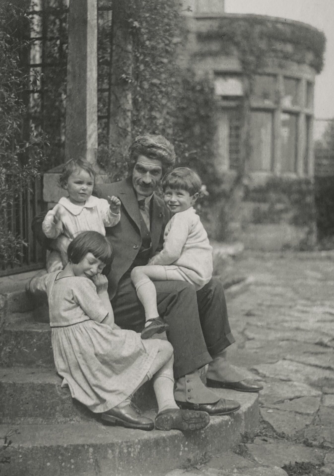 Classic vintage photo of a family seated on garden steps, evoking nostalgia.